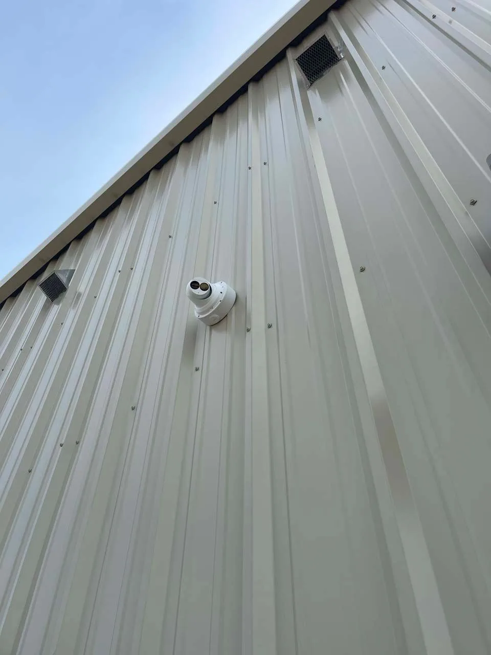 A security camera is mounted on the side of a building.